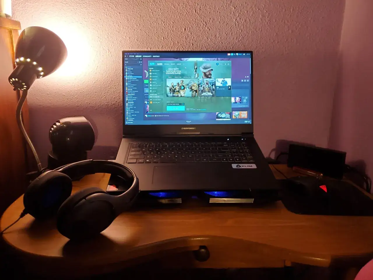 Na biurku laptop z grą Call of Duty. Słuchawki i myszka gotowe do gry. Dowiedz się, jak zainstalować Fortnite na laptopa.