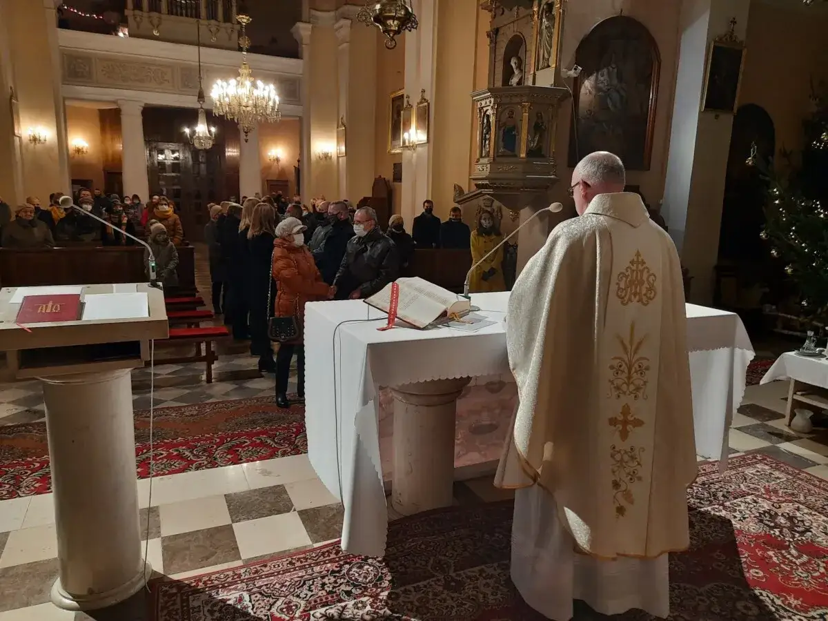 Uroczyste odnowienie przysięgi małżeńskiej w kościele. Kapłan w ozdobnej kapie stoi przy ołtarzu, a wierni obserwują ceremonię.
