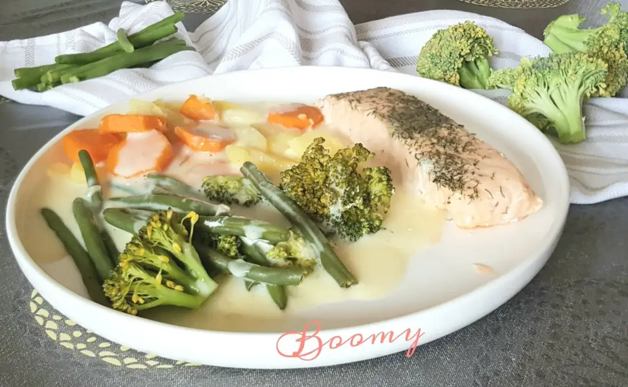 Un filet de saumon avec un assortiment de légumes verts, carottes et pommes de terre, nappés d'une sauce crémeuse. Un plat savoureux de nage de légumes.