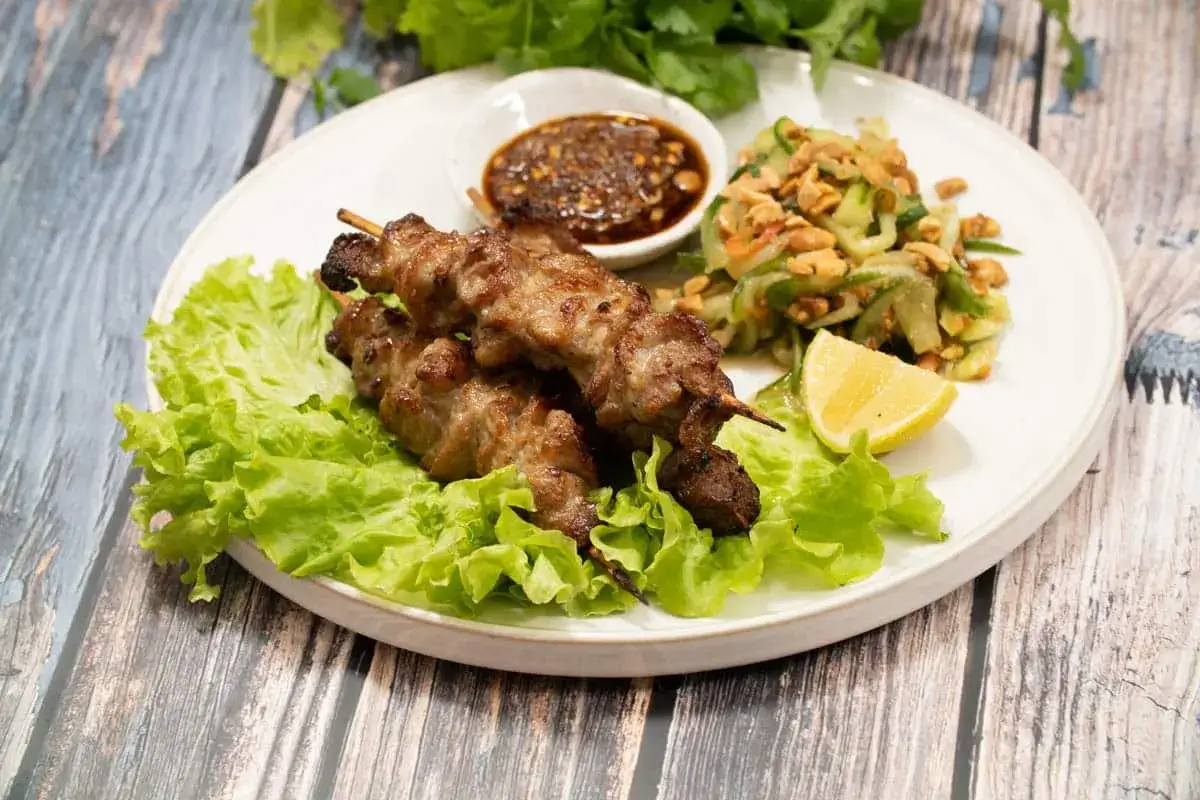 Grillspett recept: saftiga k&ouml;ttspett p&aring; salladsb&auml;dd med gurksallad, dipps&aring;s och citronklyfta.