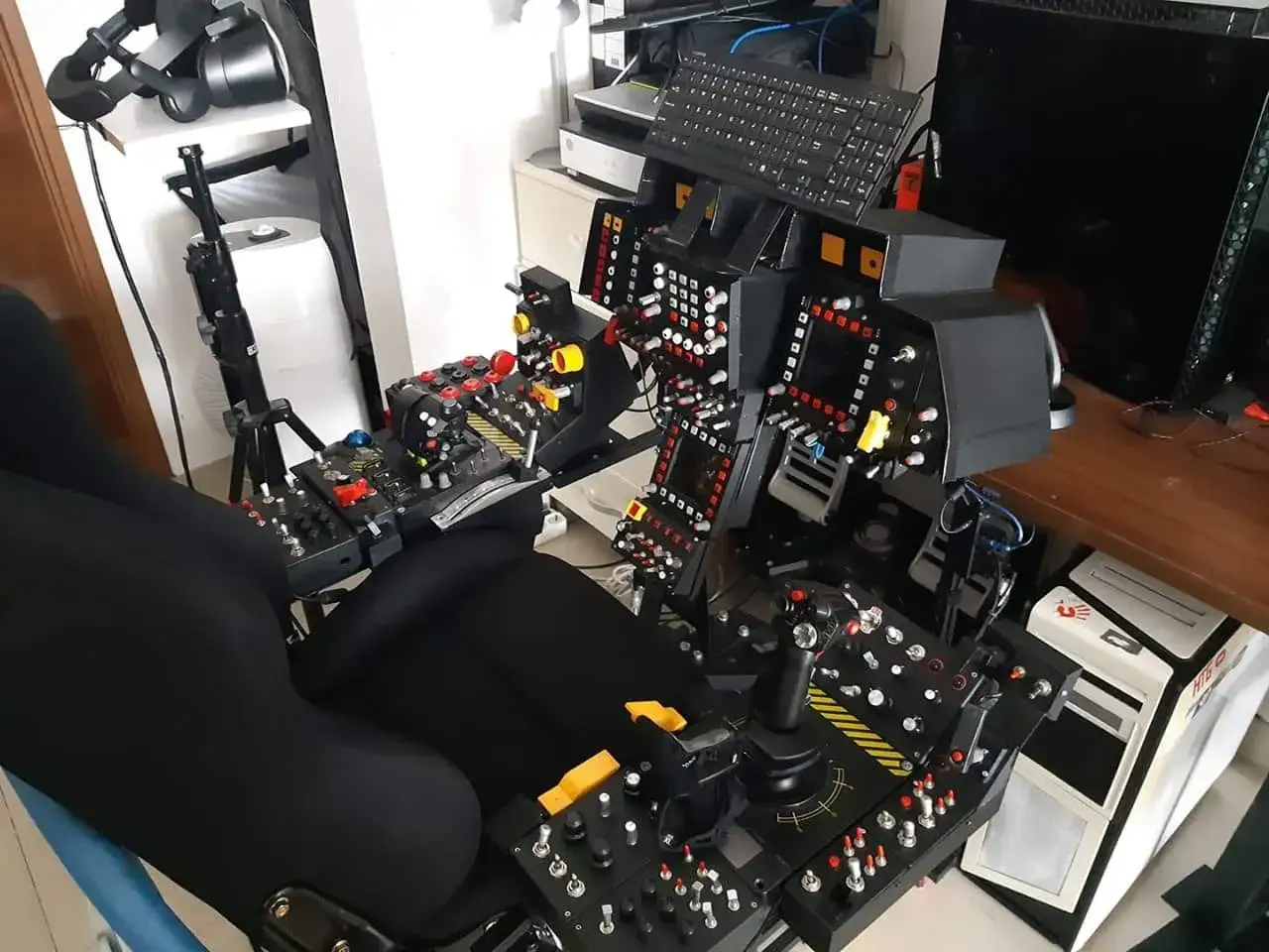 Zaawansowany kokpit do **digital combat simulator** z fotelem lotniczym, joystickiem, przepustnicą i mnóstwem przycisków.