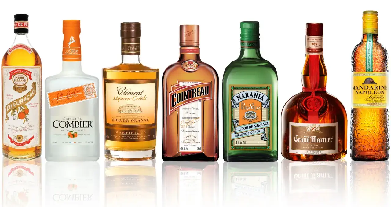Kolekcja likierów pomarańczowych, w tym Cointreau, Grand Marnier i Combier. Triple sec co to? To rodzaj likieru pomarańczowego, często używanego w koktajlach.