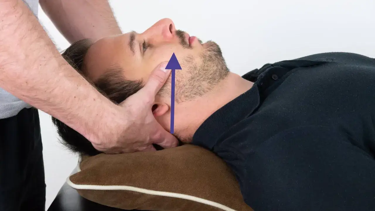 Physiotherapeut testet HWS-Beweglichkeit bei Verdacht auf Bandscheibenvorfall. Ein Pfeil zeigt die Aufw&auml;rtsbewegung des Kopfes.