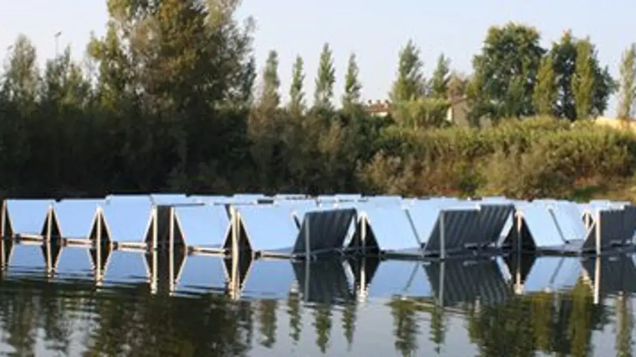 Rader av flytande solceller p&aring; en sj&ouml;, reflekterande i vattnet.