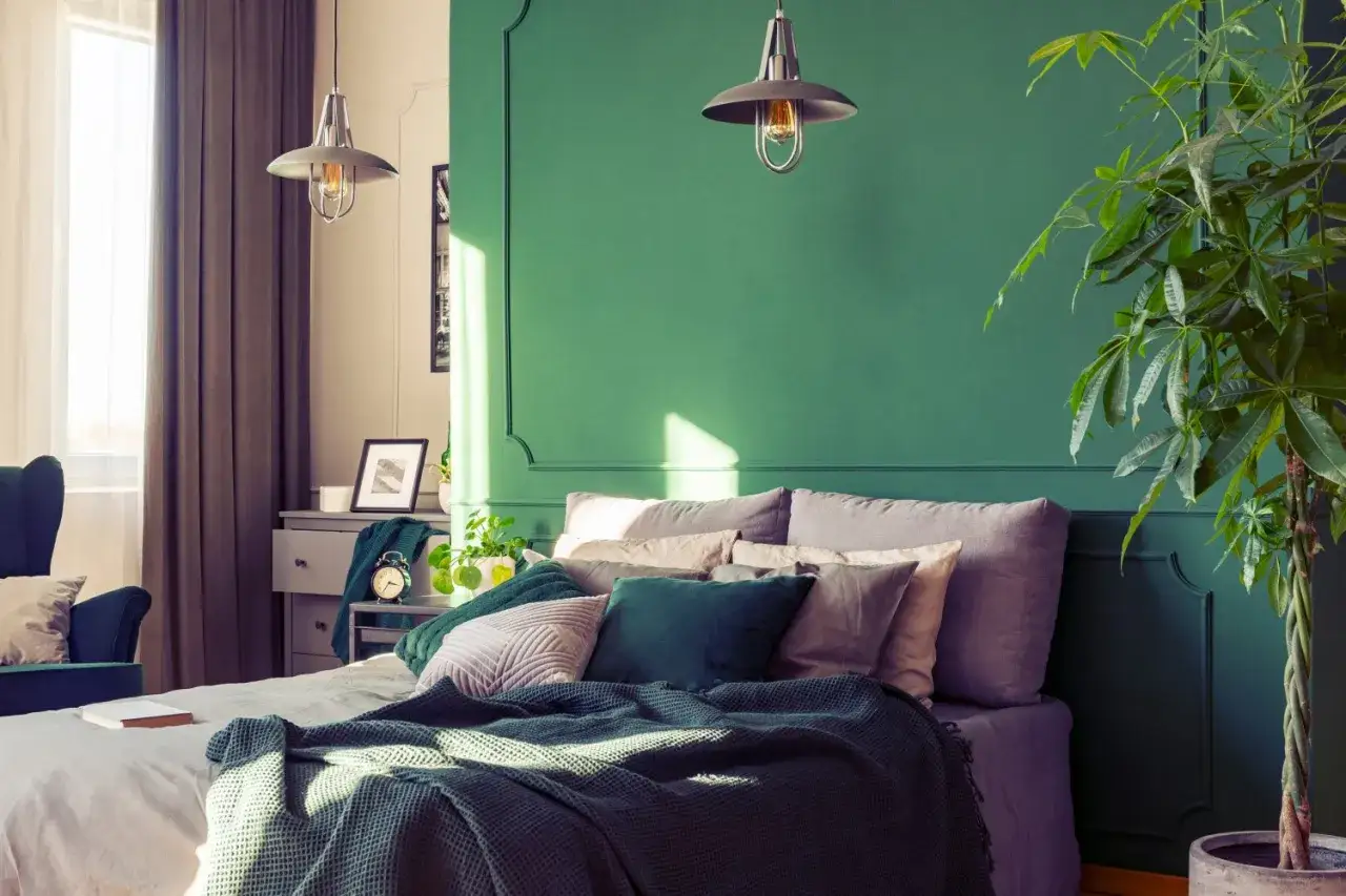 Ein gemütliches Schlafzimmer mit einer grünen Akzentwand, die Ruhe und Harmonie ausstrahlt – ideal für Feng Shui.