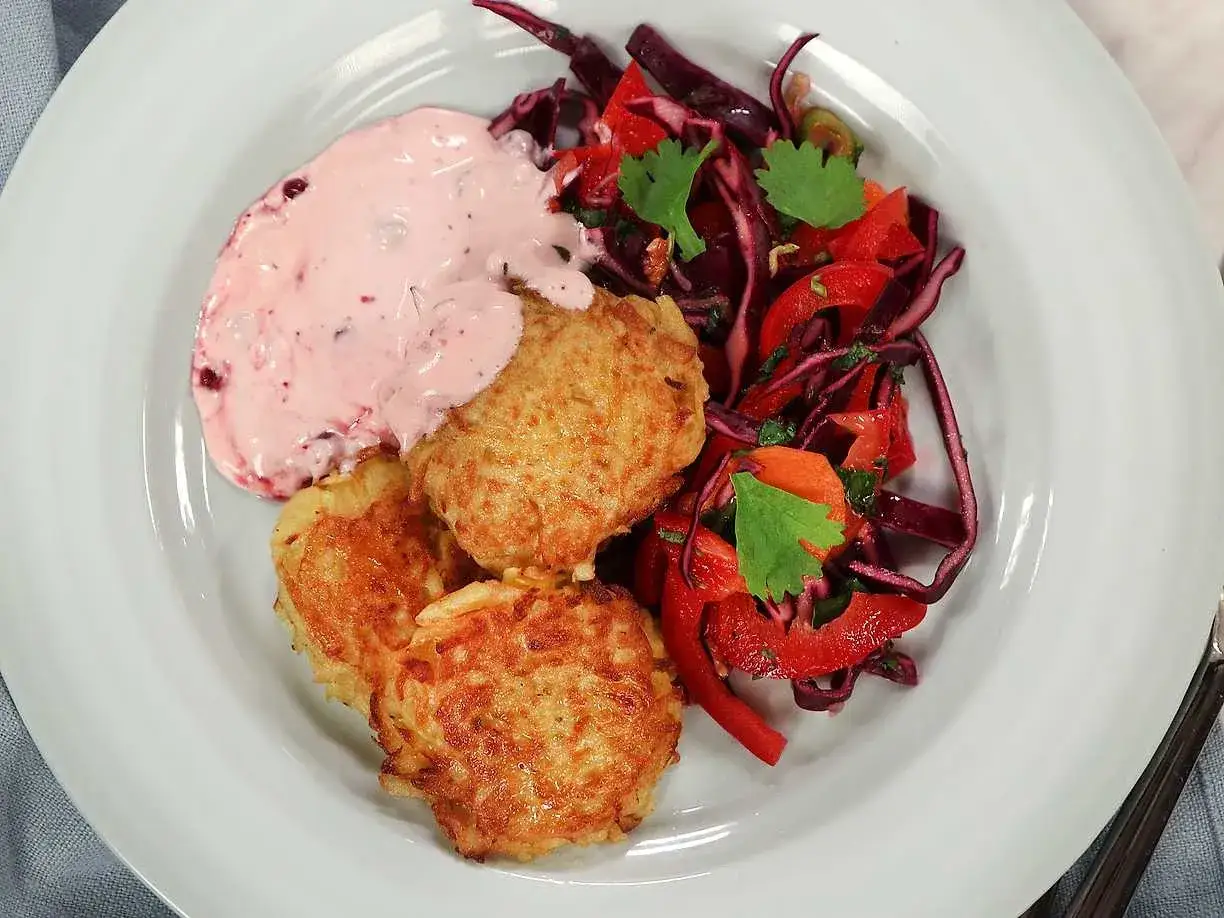 Gylla potatisbullar i airfryer serveras med en krämig lingonsås och en fräsch rödkålssallad. En perfekt och snabb måltid!