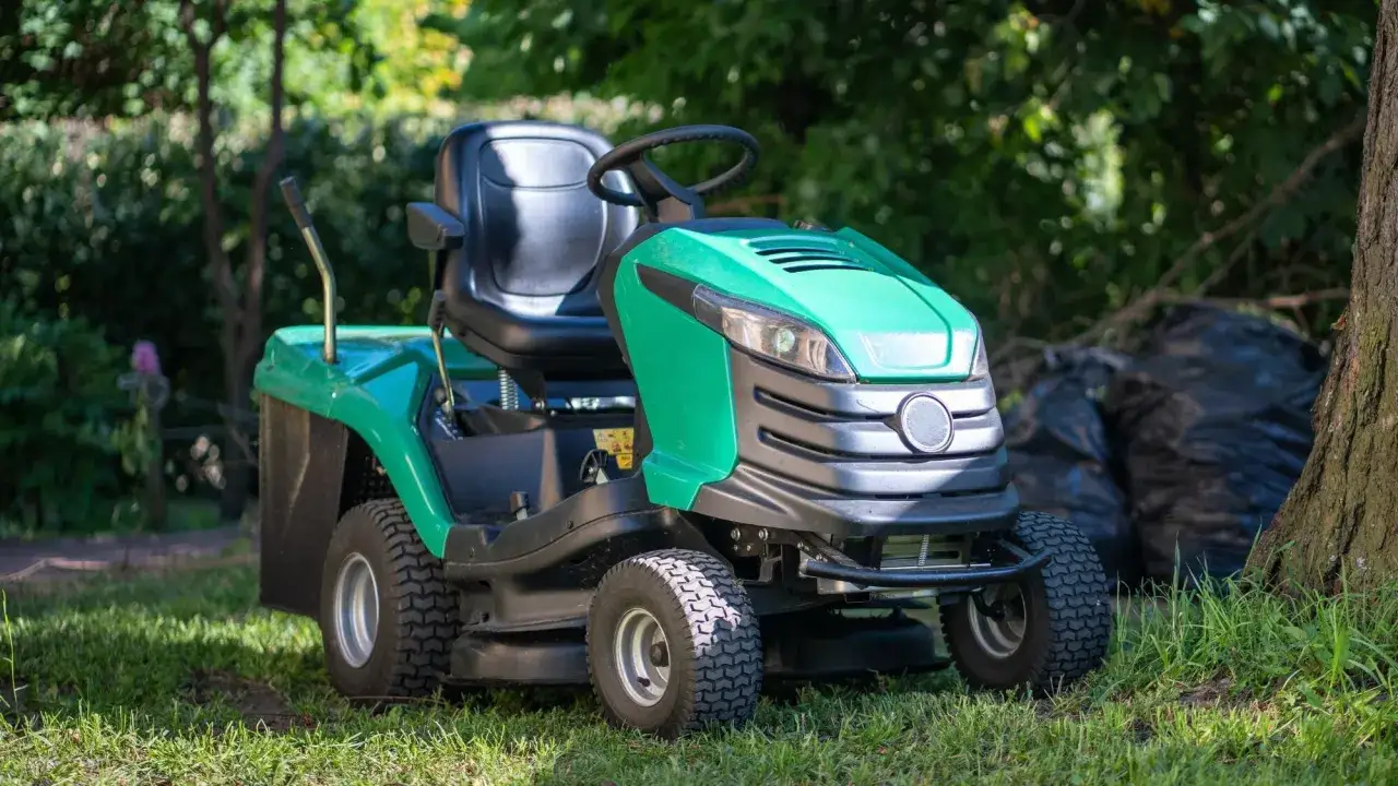 Tondeuse autoportée verte, prête pour l'entretien du jardin. Une aide précieuse pour savoir quelle tondeuse choisir.