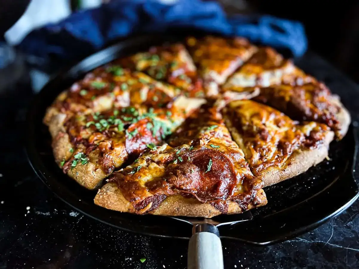 Pyszna, chrupiąca pizza prosto z piekarnika, przygotowana na kamieniu do pizzy. Idealna na rodzinny obiad.