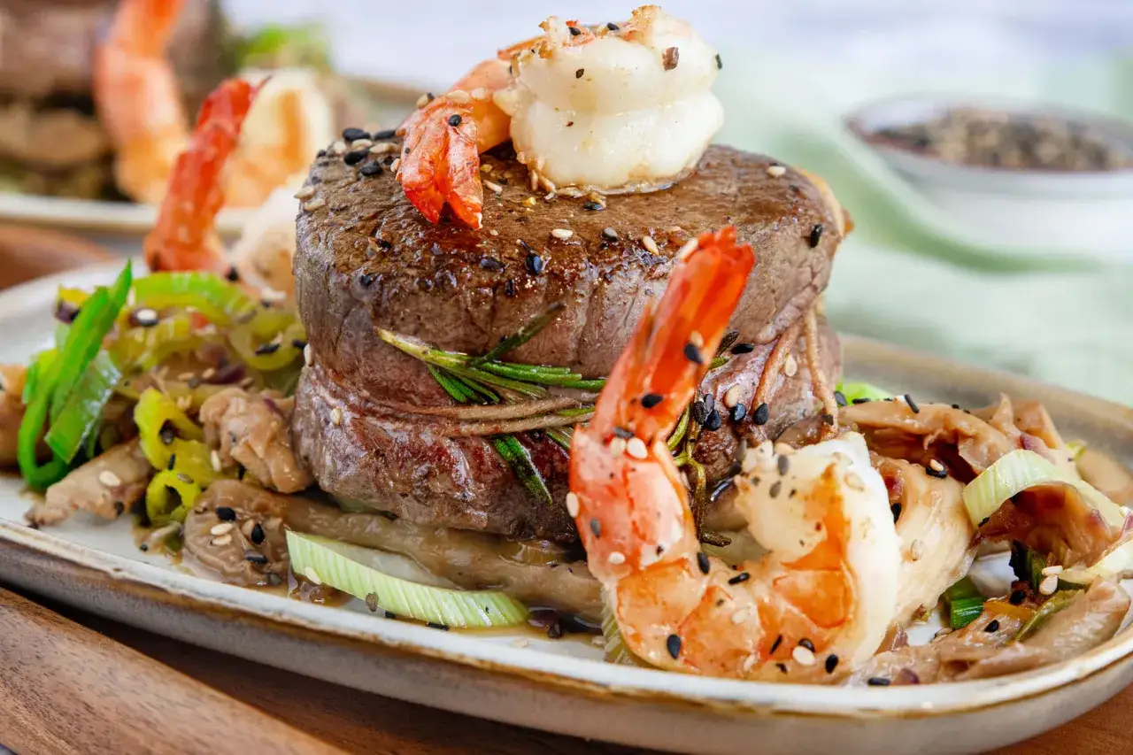 Ein saftiges Rinderfilet mit Garnelen, garniert mit Sesam und Kräutern. Ein köstliches Surf and Turf Rezept, das Lust auf mehr macht.