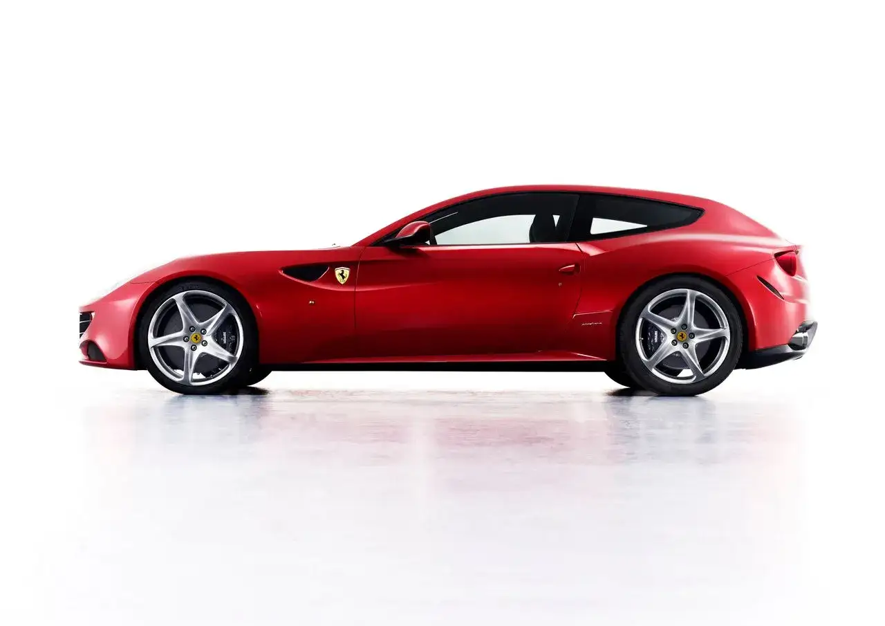 Czerwone Ferrari FF z profilu, lśniące na białym tle. Elegancka linia nadwozia i sportowe felgi podkreślają jego moc.