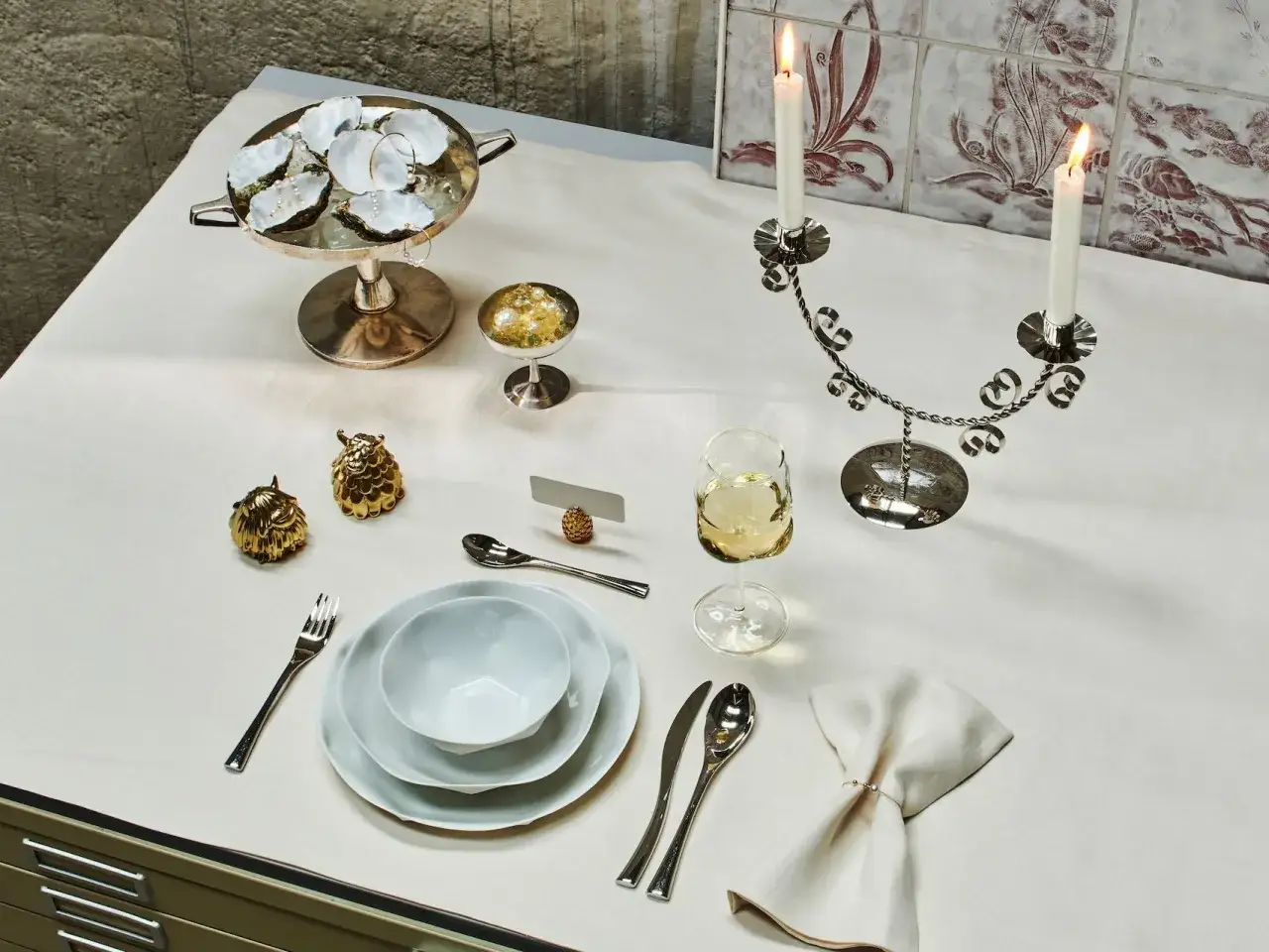 Festlich gedeckter Tisch: Austern, Kerzen, Gläser und Besteck für ein elegantes Essen. Der **Brotteller** ist bereits eingedeckt, bereit für die Gäste.