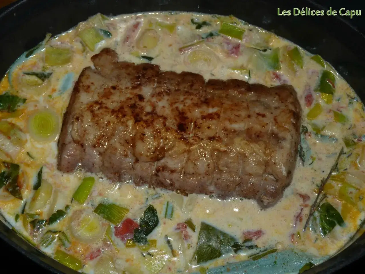 Un tendre roti de porc au lait mijote dans une sauce crémeuse avec des poireaux et des tomates. Un délice !
