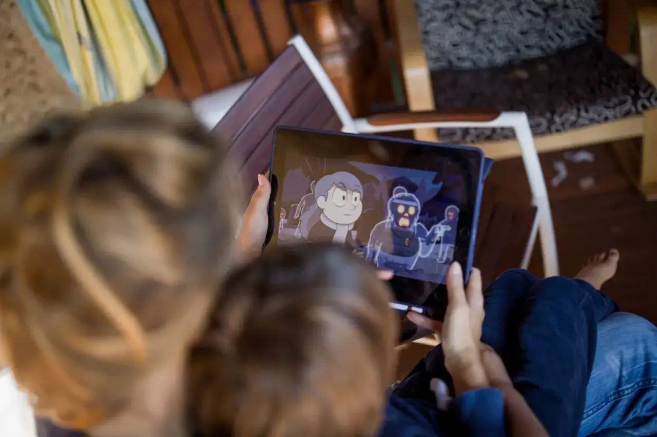 Dzieci oglądają bajki dla 4 latka na Netflixie. Na ekranie tabletu widać postacie z kreskówki Hilda.