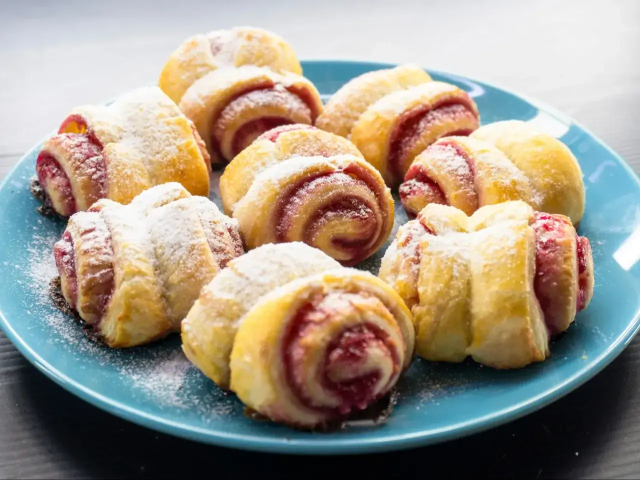 Pyszne rogaliki z dżemem posypane cukrem pudrem. Idealne, gdy pieczemy ciasto francuskie w temperaturze 200 stopni Celsjusza.