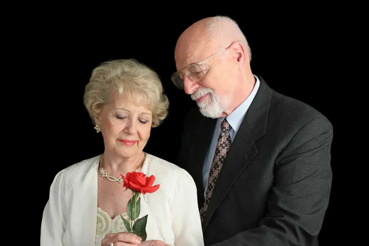 Un hombre le da una rosa a una mujer. Celebran su boda de oro, ¡50 años juntos!