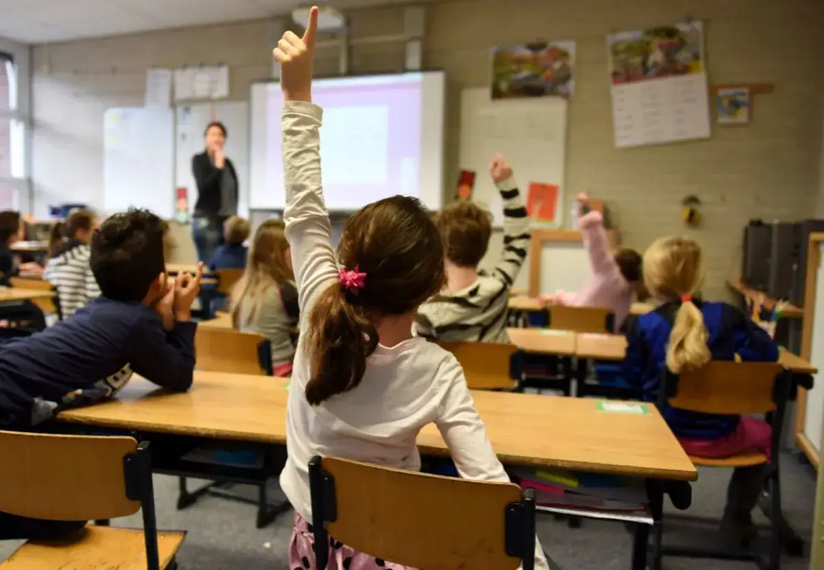 Uczniowie na lekcji podnoszą ręce. Czy to pytanie o to, ile wynosi stypendium szkolne za dobre wyniki w nauce?
