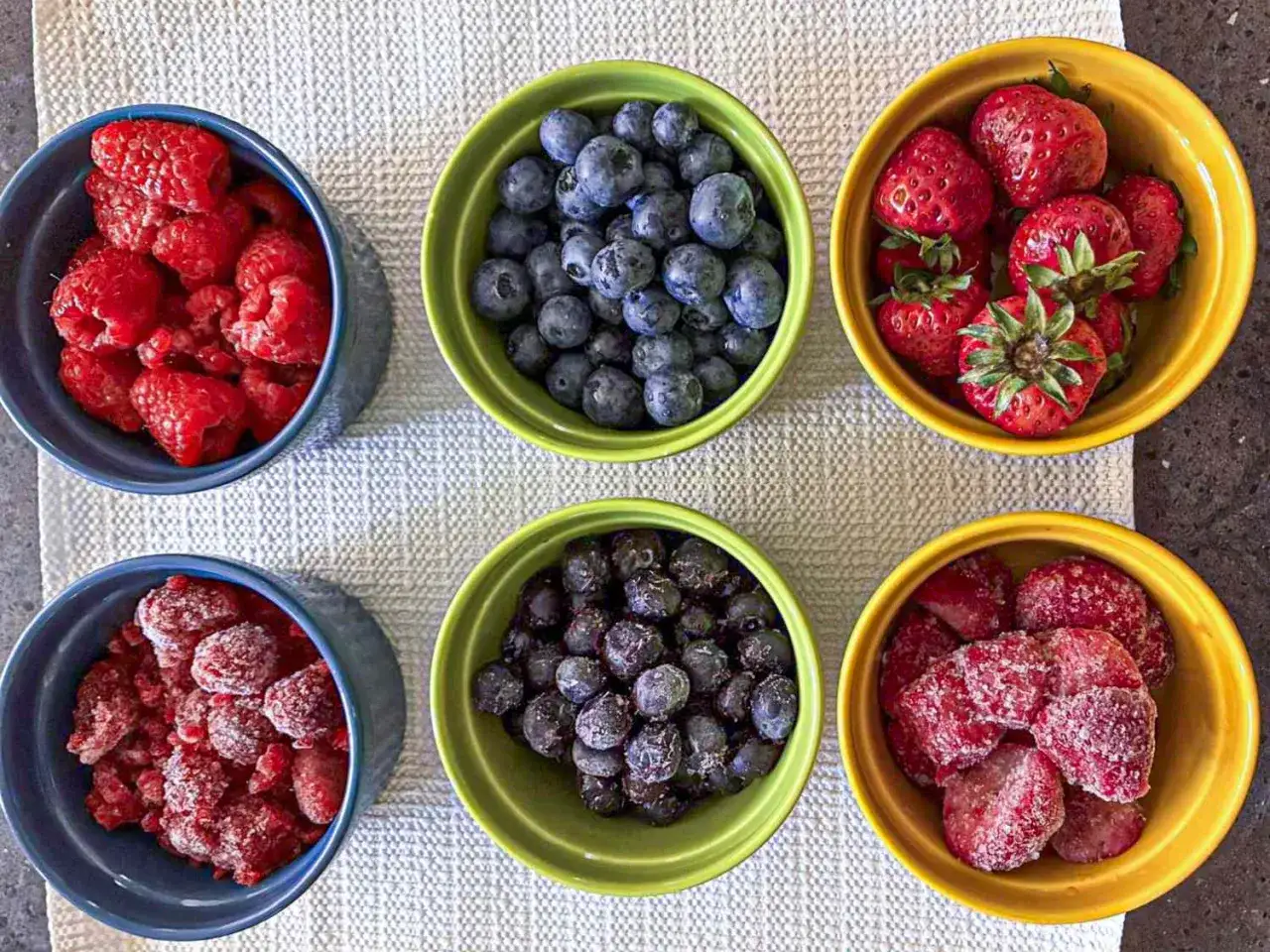 Sechs Schalen mit frischen und gefrorenen Beeren: Himbeeren, Blaubeeren und Erdbeeren. Himbeeren gesund und lecker!