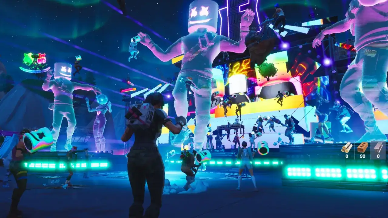 Koncert Fortnite z gigantycznym Marshmello w neonowych barwach. Tłum graczy tańczy w rytm muzyki pod rozgwieżdżonym niebem.