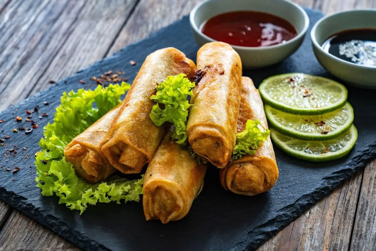 Chrupiące spring rolls z sałatką, limonką i sosami. Idealne na przekąskę.