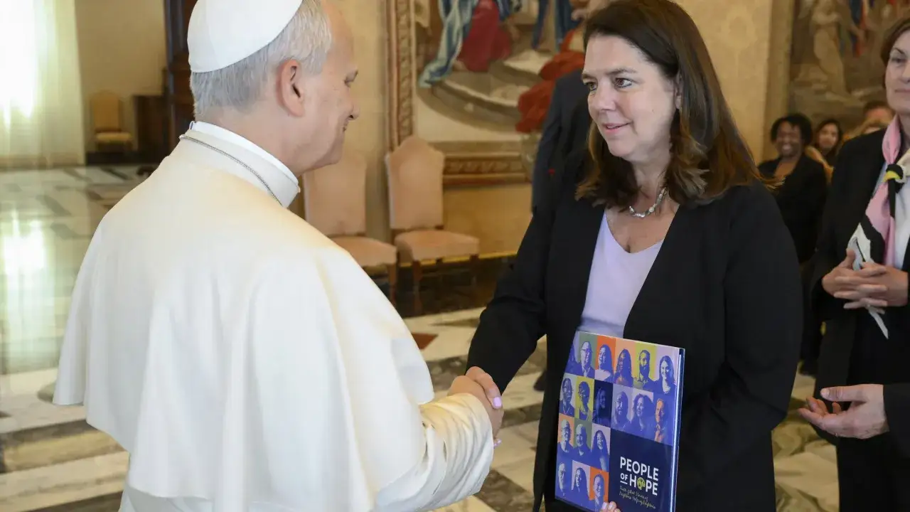 Papst Franziskus trifft eine Frau aus den USA im Vatikan. Sie &uuml;berreicht ihm ein Buch mit dem Titel 