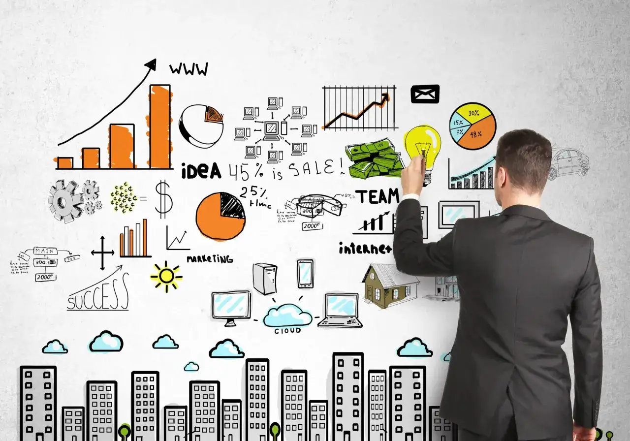Un hombre dibuja en una pared ideas de negocio: gr&aacute;ficos, dinero, bombilla, equipo, internet, c&oacute;mo hacer una segmentaci&oacute;n de mercado.