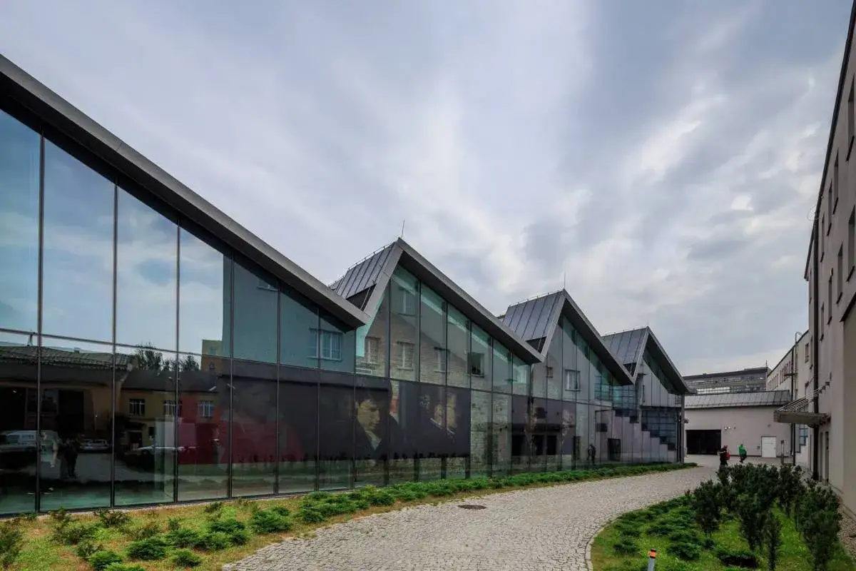 Nowoczesna architektura Muzeum Sztuki Współczesnej (MOCAK) w Krakowie z przeszkloną fasadą i widokiem na dzieła sztuki.