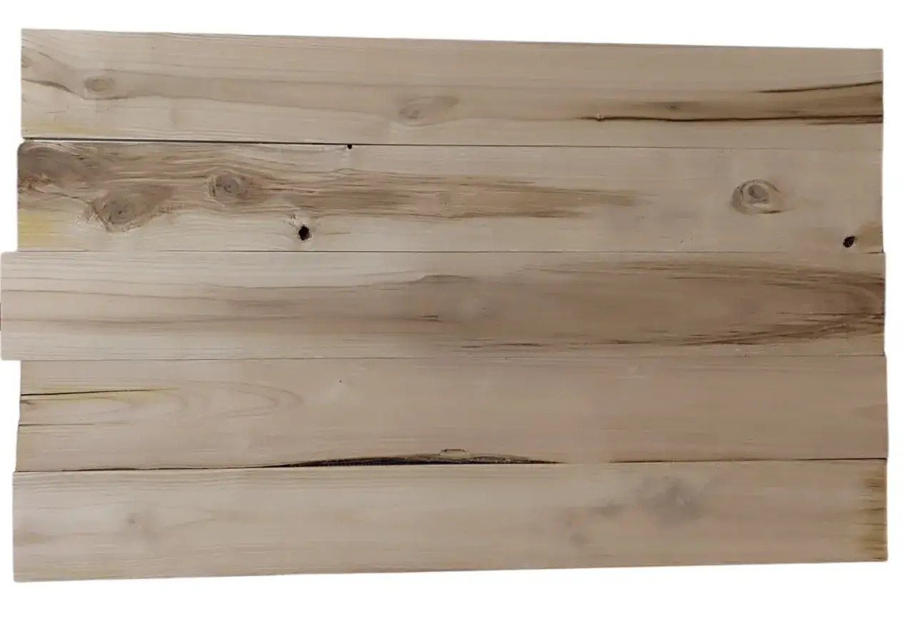 Tavole di legno chiaro, con nodi e venature evidenti, mostrano come avviene la stagionatura delle tavole, un processo naturale che le rende stabili e durevoli.