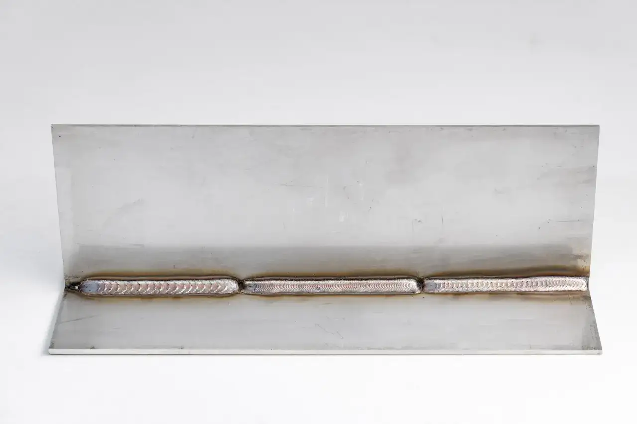 Tre cordoni di saldatura su acciaio inox, con un aspetto uniforme e lucido, dimostrano una saldatura di alta qualità.