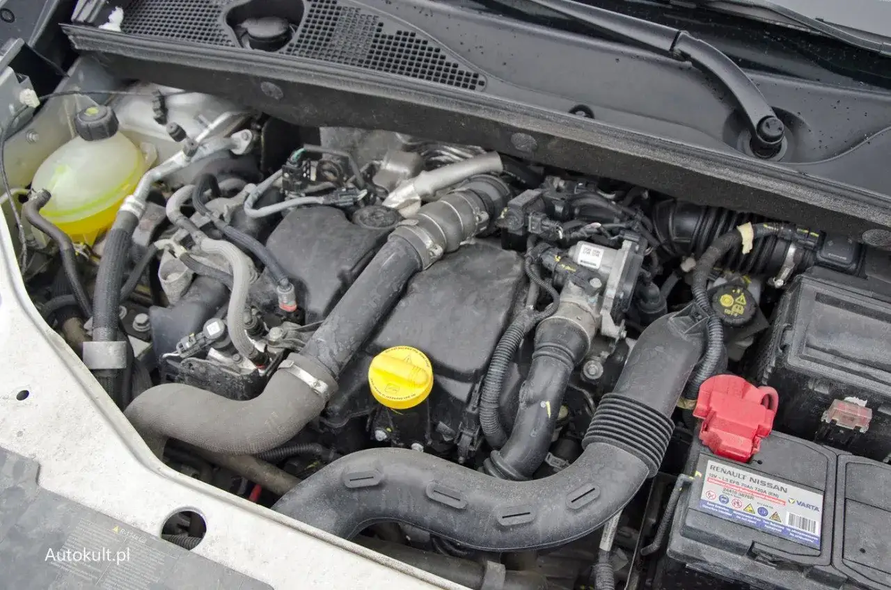 Silnik 1.5 dCi z widocznym zbiorniczkiem płynu chłodniczego, turbosprężarką i elementami układu dolotowego.