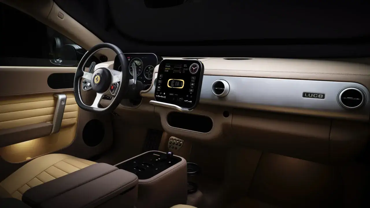 Interni lussuosi di una Ferrari elettrica, con sedili in pelle beige, volante sportivo e un ampio display digitale.