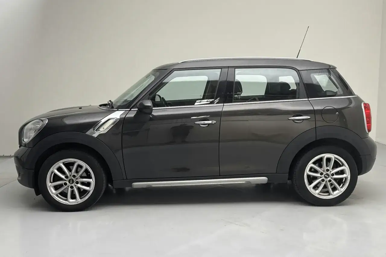 Mörkgrå Mini Countryman, redo för ett test. Denna kompakta SUV har en distinkt design med kromdetaljer och snygga fälgar.