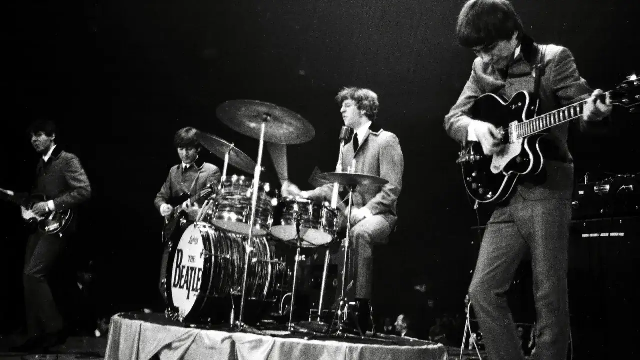 La composition des Beatles sur scène, Ringo Starr à la batterie, John Lennon et Paul McCartney à la guitare, George Harrison à la basse.