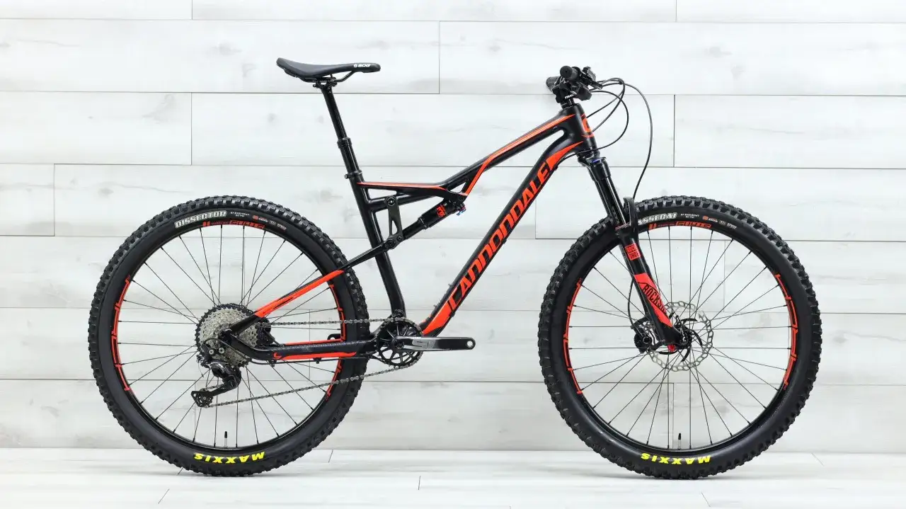 A black and orange 2017 Cannondale Habit full-suspension mountain bike with Maxxis tires and RockShox suspension.