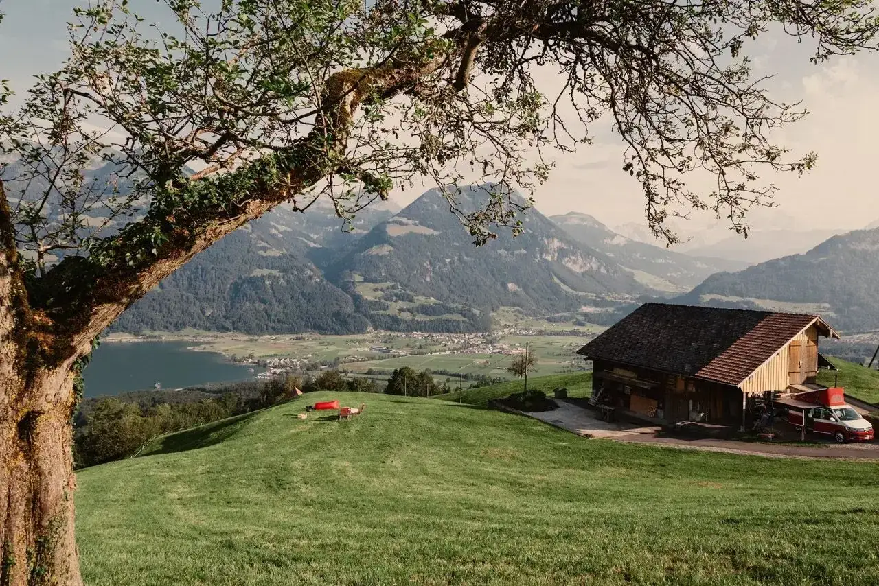 Idyllische Berglandschaft mit Bauernhaus, See und Dorf. Ein perfekter Ort f&uuml;r Basel Geheimtipps abseits des Trubels.