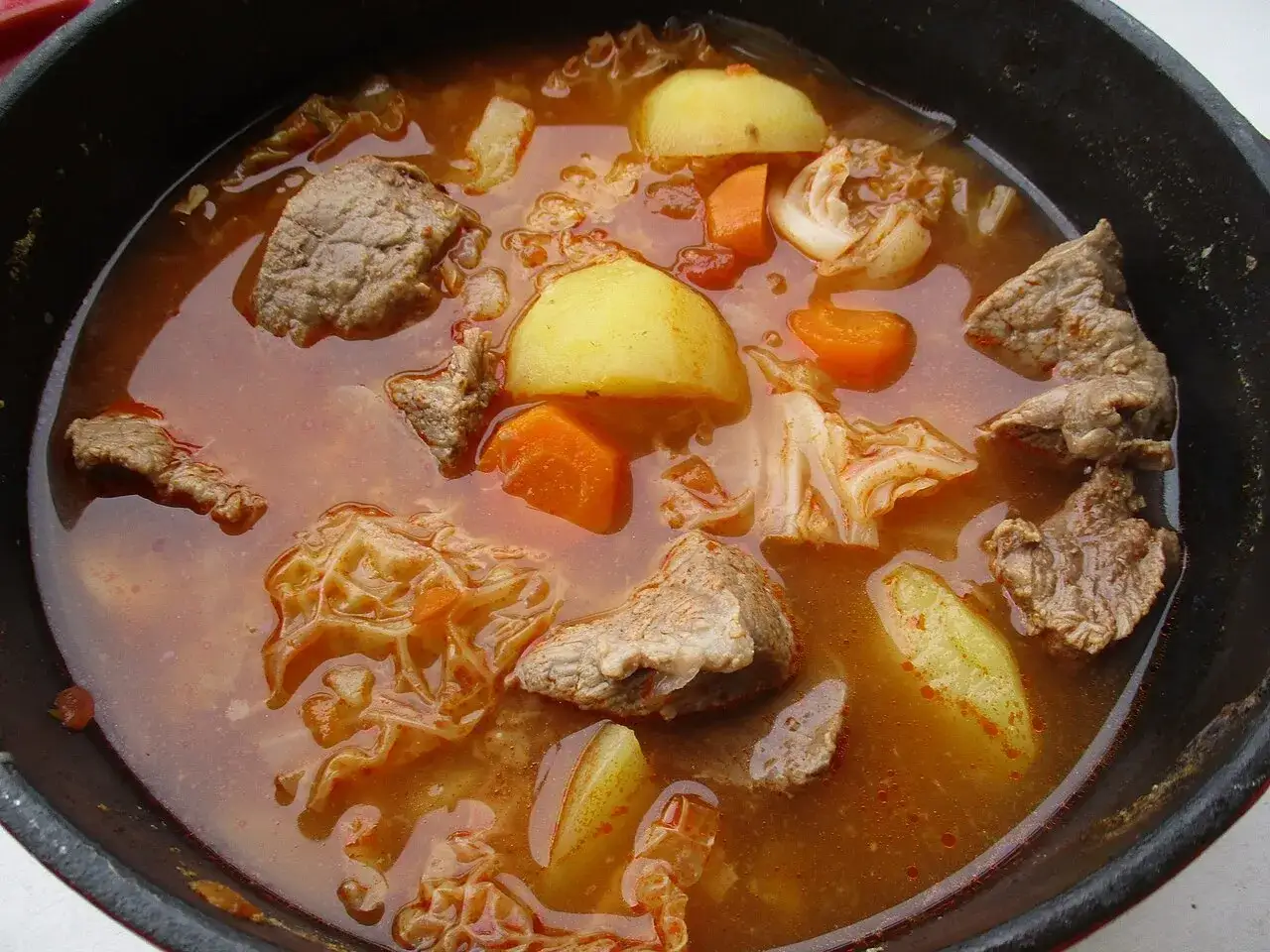 Un plat mijoté réconfortant, parfait pour une recette viking viande : morceaux de bœuf, pommes de terre, carottes et chou dans un bouillon savoureux.