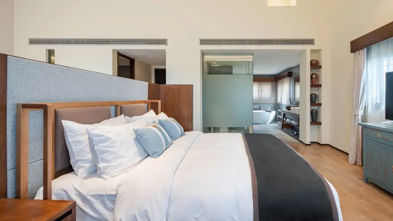 Przytulny pokój hotelowy z wygodnym łóżkiem i łazienką z wanną.