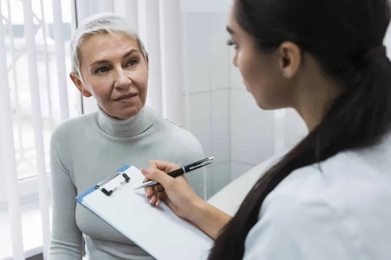 Une femme discute de sa fatigue et de sa m&eacute;nopause avec une professionnelle de sant&eacute; qui prend des notes.