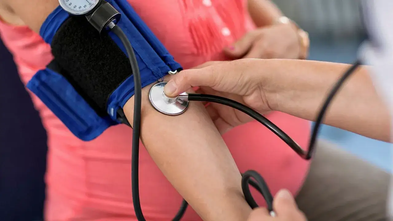 Gravid kvinna f&aring;r blodtrycket m&auml;tt. L&auml;karen lyssnar med stetoskop. Synbortfall kan vara ett tecken p&aring; h&ouml;gt blodtryck.