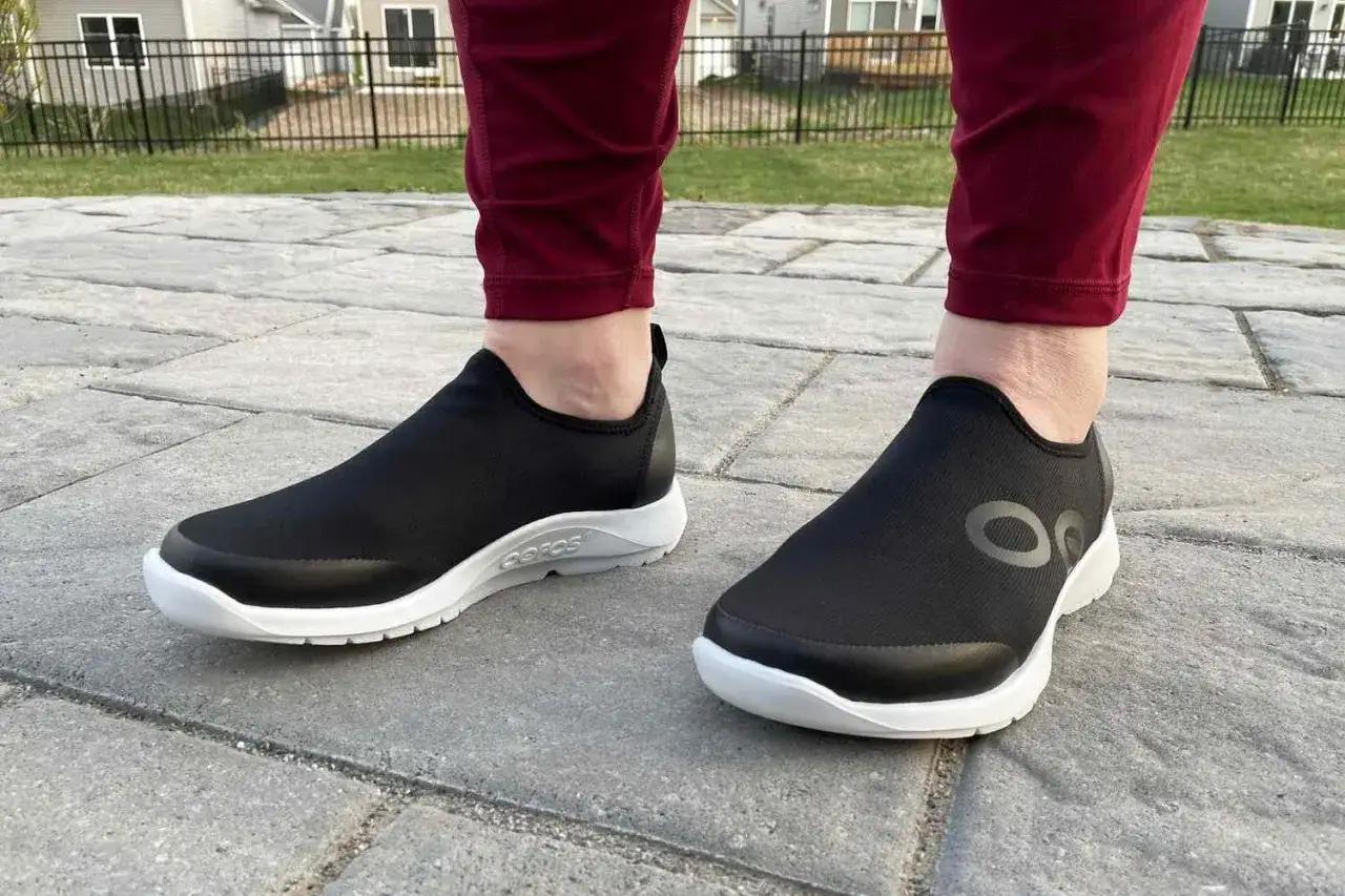 Zapatos negros c&oacute;modos con suela blanca, ideales para caminar y aliviar la fascitis plantar.