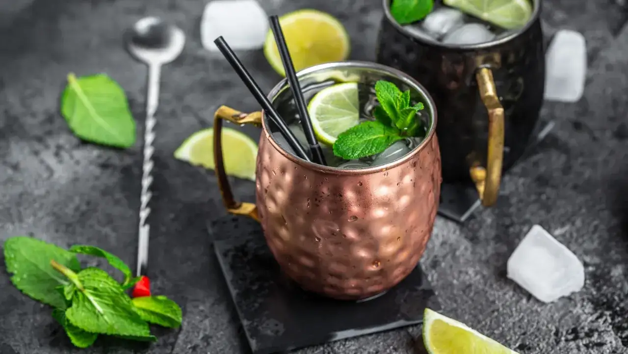 Dwa orzeźwiające Moscow Mule w miedzianych kubkach, ozdobione limonką i miętą. Idealny przepis na lato.