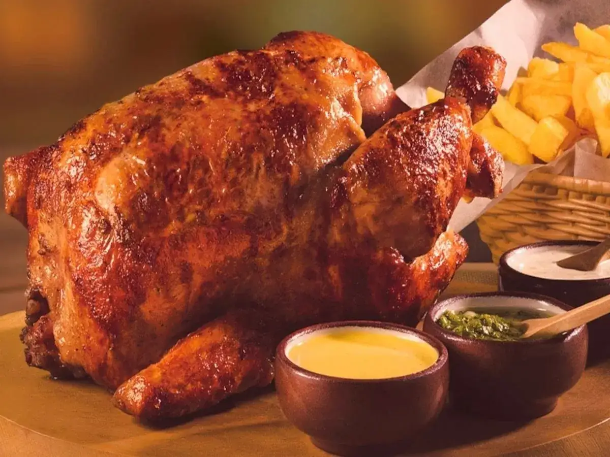 Pollo a la brasa dorado y jugoso, acompa&ntilde;ado de papas fritas crujientes y salsas cremosas.