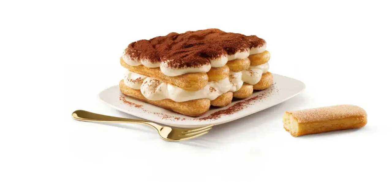 Un d&eacute;licieux tiramisu 6 personnes, g&eacute;n&eacute;reusement garni de cr&egrave;me et saupoudr&eacute; de cacao, pr&ecirc;t &agrave; &ecirc;tre d&eacute;gust&eacute; avec une fourchette dor&eacute;e.
