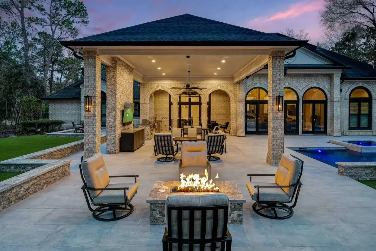 Terraza moderna con chimenea y piscina. El suelo de microcemento exterior crea un ambiente elegante y contempor&aacute;neo.