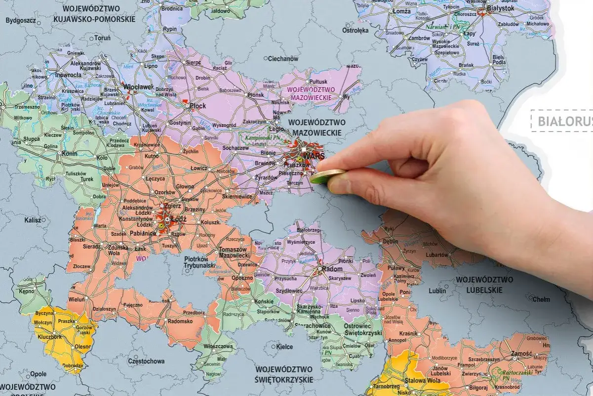 Mapa Polski z zaznaczonymi województwami, gdzie palec z monetą wskazuje na Warszawę, symbolizując najdziwniejsze miejsca w Polsce w których padły rekordowe wygrane w zdrapkach.