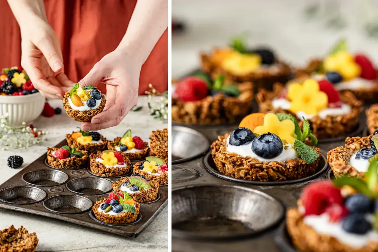 Hände halten eine Granola-Tasse mit Joghurt und Beeren. Mehrere Granola-Tassen mit Früchten sind in einer Muffinform.