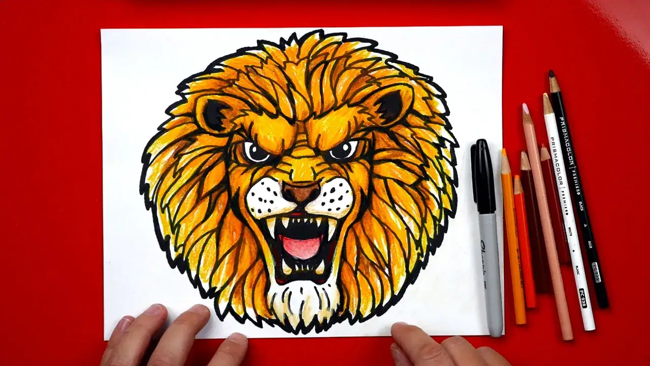 Un feroz dibujo de le&oacute;n con melena dorada y ojos penetrantes. Se aprecian l&aacute;pices de colores y un rotulador al lado.