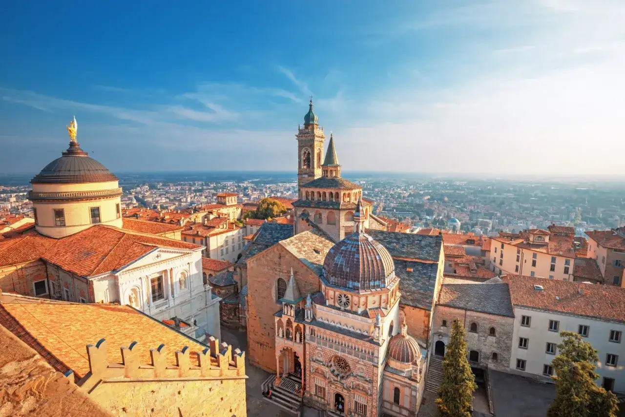 Widok na zabytkowe centrum Bergamo, w tym kopuły i wieże kościelne, idealne miejsce, by zobaczyć, co oferuje to miasto.