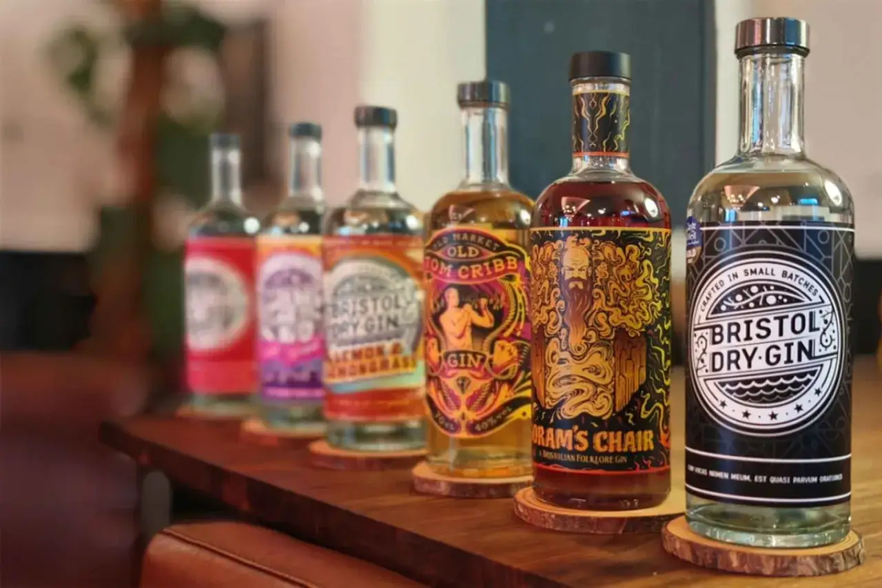 Rząd butelek ginu Bristol Dry Gin. Każda butelka ma unikalną etykietę, sugerującą bogactwo smak&oacute;w, jak smakuje gin.