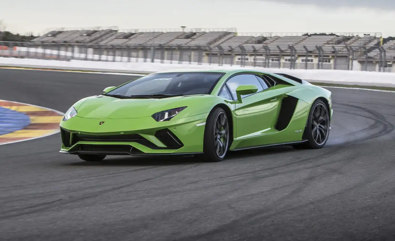 Jaskrawozielony Lamborghini Aventador na torze wyścigowym, zostawiający ślady opon.