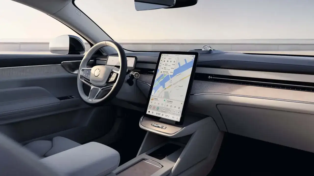 Interno moderno di una Volvo ES90 con grande schermo centrale che mostra il navigatore.
